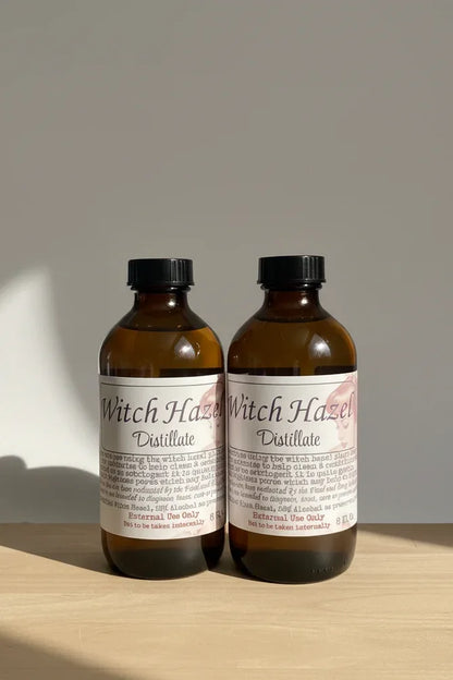 Two bottles of Witch Hazel Distillate with labels on a light background