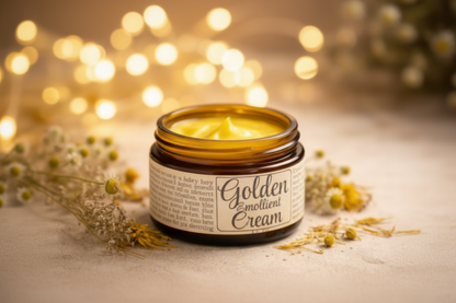 Jar of Golden Emollient Cream with a label on a textured surface with flowers.