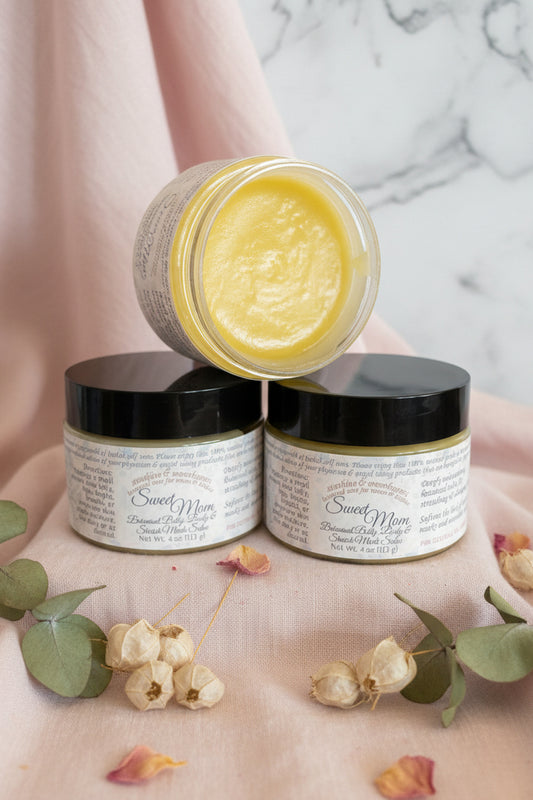 Three jars of a yellow salve with visible labels on a dark surface